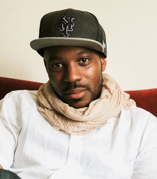 Portrait of Bobby Kashif Cox wearing a Mets cap and a cream scarf